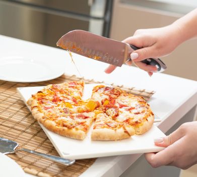 kitchen knife over homemade pizza on the table.