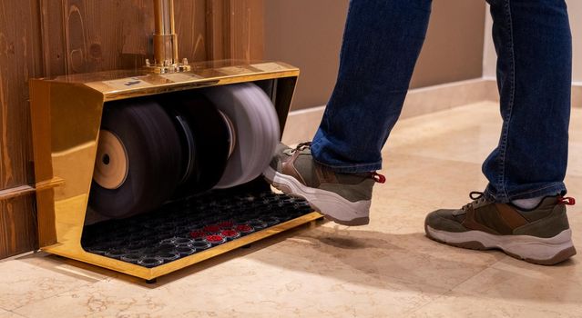 man cleaning sneakers with shoe polish machine.