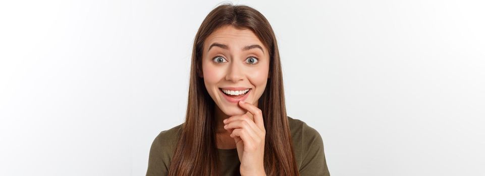 Close-up portrait of surprised beautiful girl holding her head in amazement and open-mouthed. Over white background.