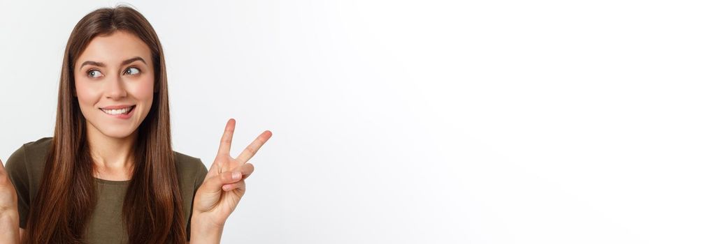 Young woman showing two fingers, positive or peace gesture, on white