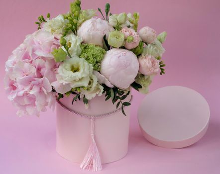 Flowers in round luxury present boxes. Bouquet of pink and white peonies in paper box. Mock-up of hat box of flowers with free copyspace for text. Interior decoration in in pastel colors