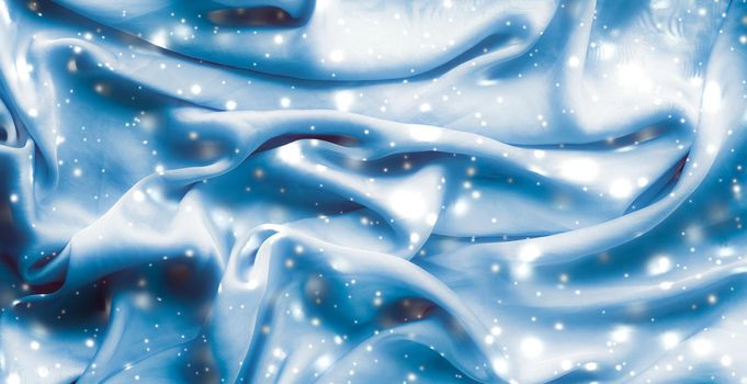 Winter fashion, shiny fabric and glamour style concept - Magic holiday blue soft silk flatlay background texture with glowing snow, luxury beauty abstract backdrop