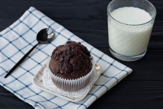 Homemade chocolate muffins or cake with a glass of milk. Place for text. Homemade or bakery pastries for breakfast or celebration. High quality photo