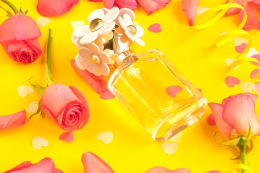 Perfume with a sweet floral scent in a glass bottle. perfume with flowers roses and rose petals on a yellow background. international womens day concept, lovers day and spring. mother's day