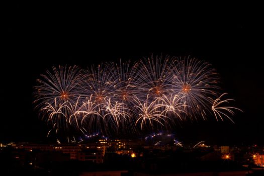 bright lilac and orange fireworks in a night sky