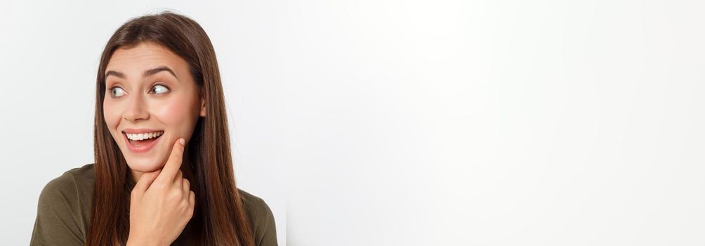 Close-up portrait of surprised beautiful girl holding her head in amazement and open-mouthed. Over white background.