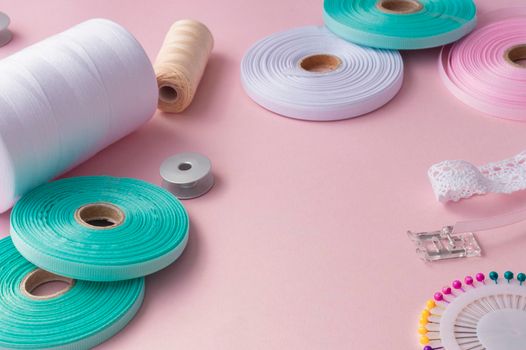 Handmade and sewing background. sewing accessories for needlework on pink background. Spool of thread, multicolored tapes, sewing supplies. Handmade set with copy space. High quality photo