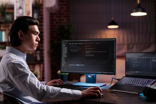 Asian engineer developing app software on computer, working with binary code program to create firewall security server. Programming application code with cloud computing on high tech interface.