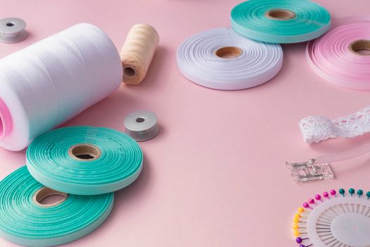 Handmade and sewing background. sewing accessories for needlework on pink background. Spool of thread, multicolored tapes, sewing supplies. Handmade set with copy space. High quality photo