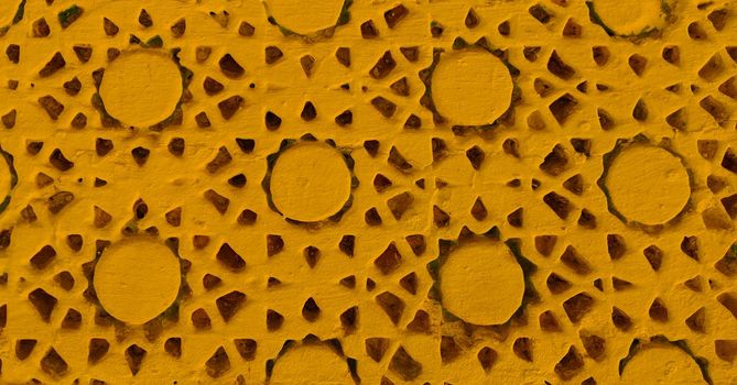 Yellow painted texture of handcrafted details. Handwork on the wall.