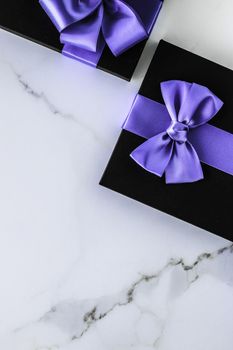 Wedding present, shop sale promotion and anniversary celebration concept - Luxury holiday gifts with lavender silk ribbon and bow on marble background