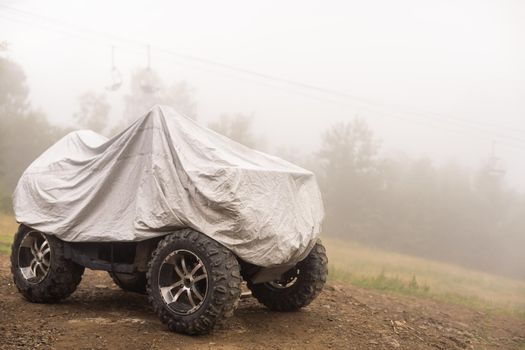tracked quad bike covered with a cape stands