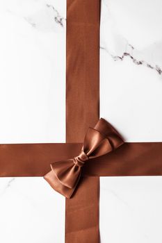 Holiday gift, decoration and sale promotion concept - Chocolate brown silk ribbon on marble background, flatlay