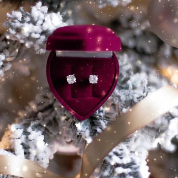 Timeless luxury, romantic and happy celebration concept - Diamond earrings in heart shaped jewellery gift box on Christmas tree, love present for New Years Eve, Valentines Day and winter holidays