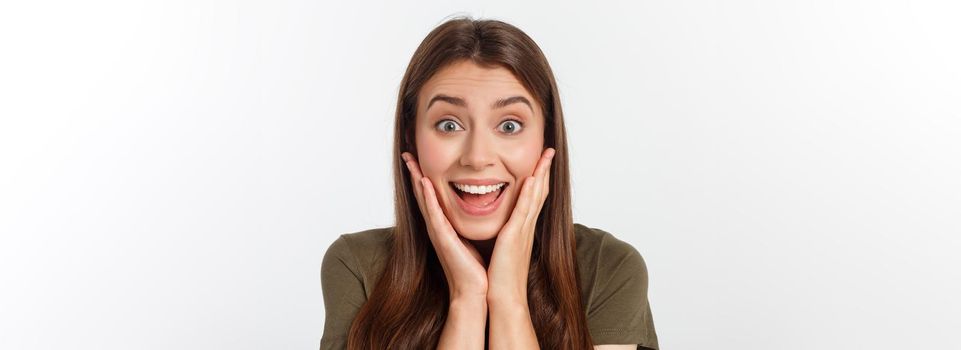 Close-up portrait of surprised beautiful girl holding her head in amazement and open-mouthed. Over white background.