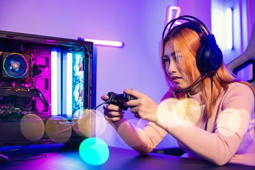 Woman wear gaming headphones playing live stream esports games console at home, Gamer using joystick controller for virtual tournament plays online video game with computer neon lights, Esport concept