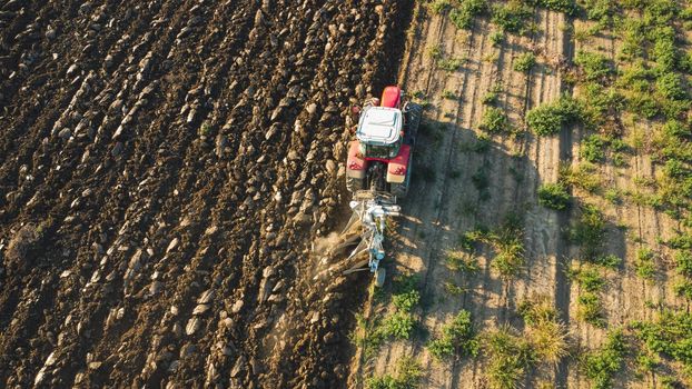 Aerial view with drone of tractor plowing the land in the countryside.