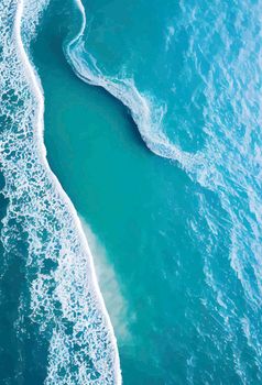 Beach and waves from above. water background from the top. Summer attacks from the air. Aerial view of a blue ocean.