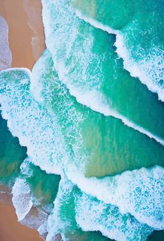 Beach and waves from above. water background from the top. Summer attacks from the air. Aerial view of a blue ocean.