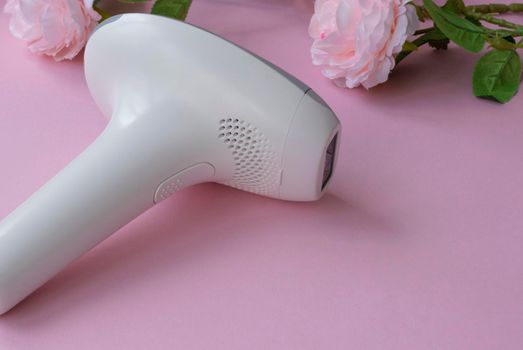 home modern laser epilator. Hair Remover offering Permanently Smooth Skin. Flash Epilator Laser on a pink background. Female blog concept. High quality photo