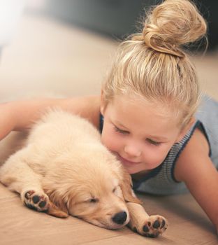 Loving and growing together. An adorable little girl with her puppy at home