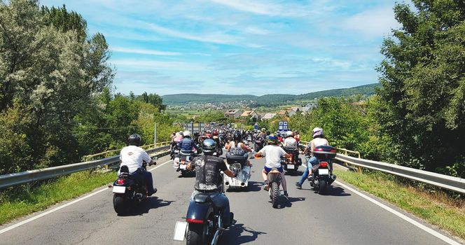 Motorcycle group riding on the road, within a forest . High quality photo