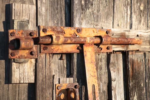 Old rusty damper on a wooden door