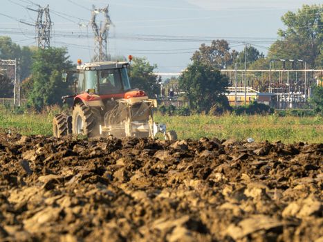 farmer with tractor plowing the land in the countryside.