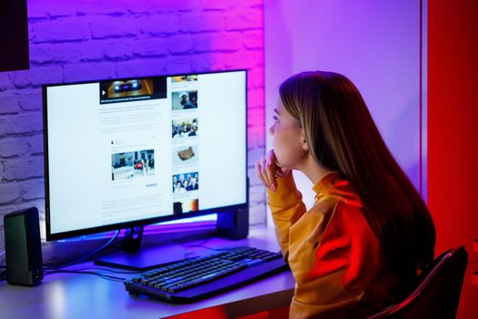 girl freelancer looks on the computer screen news about forest fires and the virus COVID-19