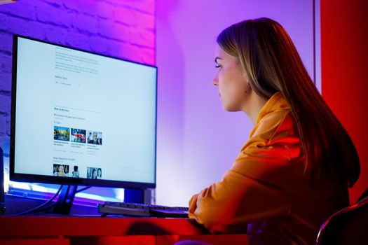 girl freelancer looks on the computer screen news about forest fires and the virus COVID-19