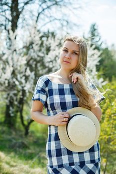 beautiful girl in a dress walking in the spring forest where the trees bloom