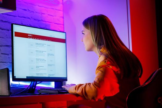 girl freelancer looks on the computer screen news about forest fires and the virus COVID-19