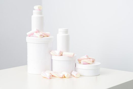 Cosmetic skincare packaging. Beauty product on white background. White jars with marshmallows on the white table