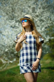 beautiful girl in a dress walking in the spring forest where the trees bloom