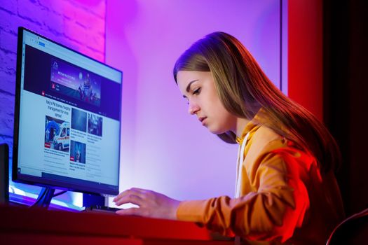 girl freelancer looks on the computer screen news about forest fires and the virus COVID-19