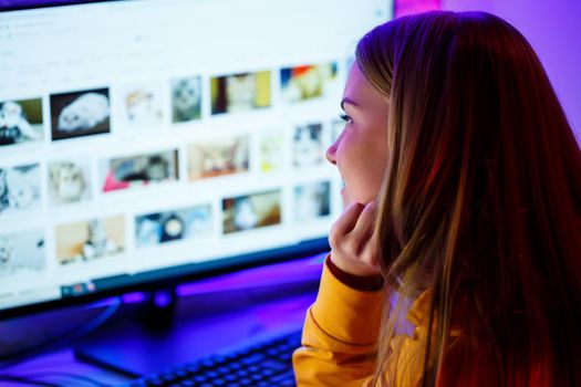 girl freelancer looks on the computer screen news about forest fires and the virus COVID-19