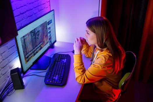 girl freelancer looks on the computer screen news about forest fires and the virus COVID-19