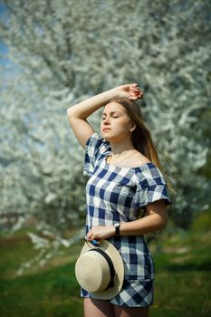 beautiful girl in a dress walking in the spring forest where the trees bloom