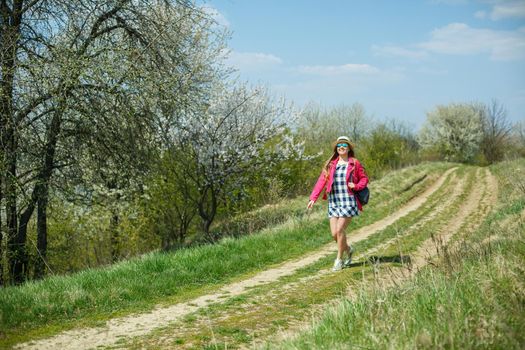 beautiful girl in a dress walking in the spring forest where the trees bloom