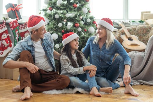 happy family mother, father and child daughter near Christmas tree at home.