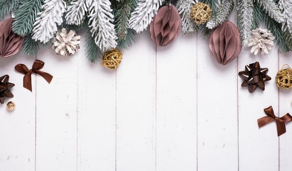 Festive creative christmas composition with pine, paper Christmas balls and other decor flat lay on wooden background.