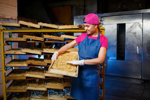 Make the noodles. Pasta factory. Spaghetti production. Raw pasta. Worker with a box of pasta. Girl works in the production of pasta