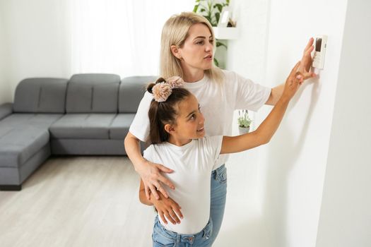 daughter and mother turn on the climate control in the apartment.