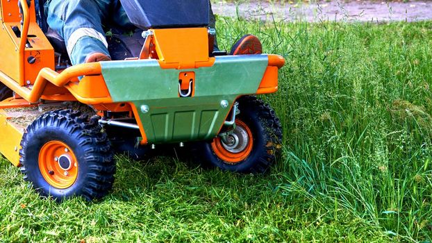 a machine for cutting the grass on a lawn. Professional grass cutting on lawns with a mini tractor lawn mower. .