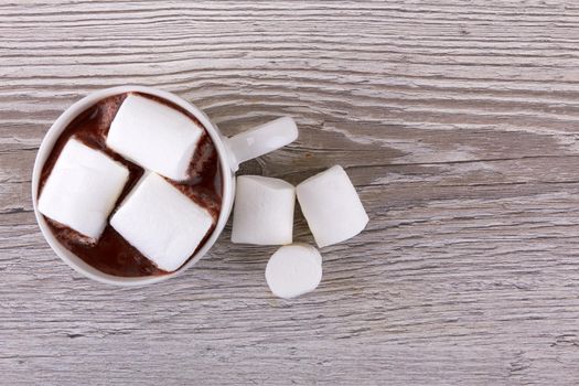 Cacao with marshmallows on a wooden surface