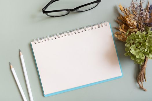 Blank sheet paper notebook on colored background top view. Flat lay.