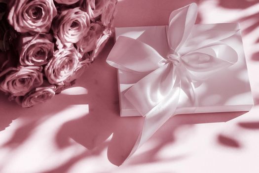 Happy holidays, luxe shopping and love gifts concept - Luxury holiday silk gift box and bouquet of roses on blush pink background, romantic surprise and flowers as birthday or Valentines Day present