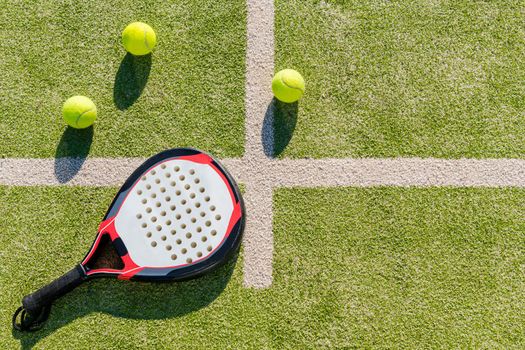 top view of a paddle tennis racket and balls on court of artificial turf, indoor sports concept and sporty lifestyle