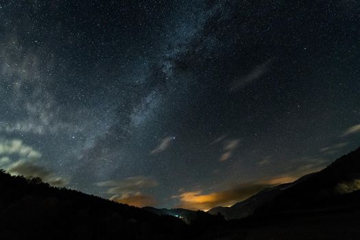 wonderful starry night sky with the Milky Way over the valley of a mountain landscape, observation of the universe concept