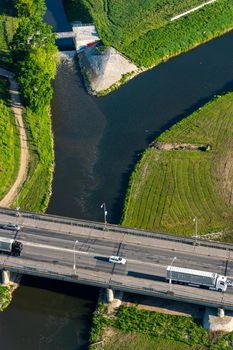 Aerial view of a bridge over a river with several cars in the morning on a summer day